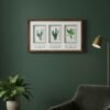 The Native Irish Fern Leaf – Original Ceramic Wall Art is displayed on a dark green wall above a velvet armchair, with a gold floor lamp and potted plant nearby, creating a cozy and modern interior.