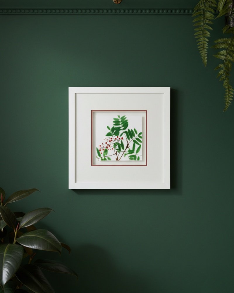 The "Large Colourful Meadow Mix – Fine Art Print" hangs on a dark green wall, featuring pink and white cows with green leaves, surrounded by lush, leafy plants.