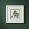 The Large Colourful Meadow Mix – Fine Art Print, featuring vibrant green leaves and red berries, hangs on a dark green wall. A white frame with double mat adds depth to this simple, modern botanical display.