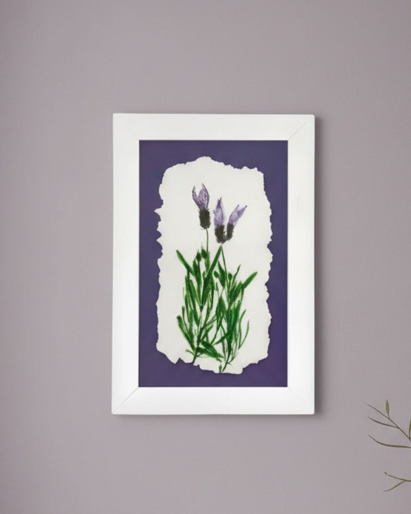 Wild Meadow Mix (Medium): A framed botanical artwork by an Irish artist, showcasing two purple flowers with green stems and leaves on torn-edged white paper, set on a dark purple background and displayed on a light gray wall.