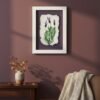 The Dill – Original Ceramic Wall Art, inspired by Irish design, is displayed on a mauve wall above a wooden table with a vase of dried leaves. A beige knit blanket warms the brown chair nearby, creating a cozy scene.