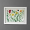 The Rosemary – Original Ceramic Wall Art features a white frame and displays an Irish-inspired wildflower illustration with red, yellow, orange, blue, and pink blooms on green stems against a white background, hanging on a gray wall.
